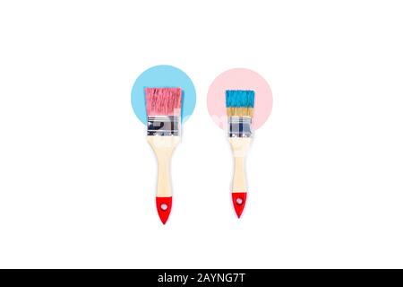 Renovation picture. Isolated white background with pink and blue paint brushes located on color paper circles. Flat lay, top view, copy space. Stock Photo