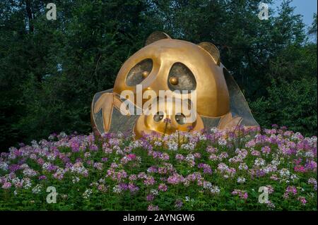 A Panda statue with flowers in the garden of the Chengdu Panda Breeding Center in Chengdu, Sichuan Province in China. Stock Photo