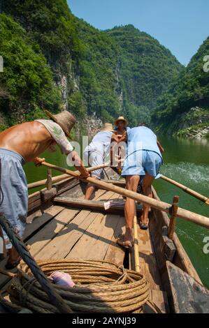 Chinese men rowing a traditional Sampan boat near Badong on the Shennong stream, a tributary of the Yangtze River at the Wu Gorge (Three Gorges) in Ch Stock Photo