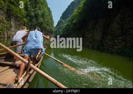 Chinese men rowing a traditional Sampan boat near Badong on the Shennong stream, a tributary of the Yangtze River at the Wu Gorge (Three Gorges) in Ch Stock Photo