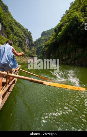 Chinese men rowing a traditional Sampan boat near Badong on the Shennong stream, a tributary of the Yangtze River at the Wu Gorge (Three Gorges) in Ch Stock Photo