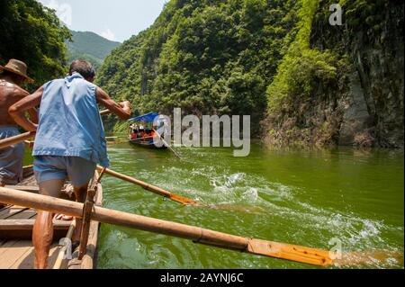 Chinese men rowing a traditional Sampan boat near Badong on the Shennong stream, a tributary of the Yangtze River at the Wu Gorge (Three Gorges) in Ch Stock Photo