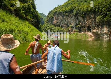 Chinese men rowing a traditional Sampan boat near Badong on the Shennong stream, a tributary of the Yangtze River at the Wu Gorge (Three Gorges) in Ch Stock Photo