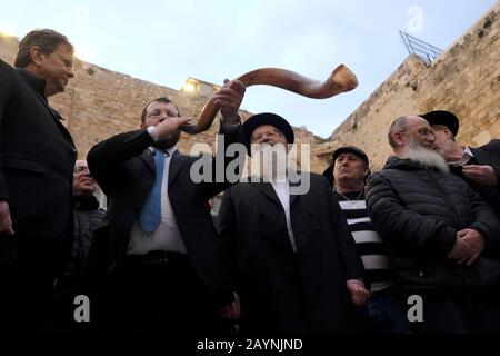 Israel, Jerusalem 16th February 2020. A religious Jew blows the Shoffar made from a ram horn during a prayer for the people of China at the Western Wall, in effort to stop the COVID-19 epidemic. The prayer was conducted by the chief rabbi of Safed, Shmuel Eliyahu who argued that just as Abraham prayed for the recovery of Abimelech (Genesis 20:17), so should the Jewish people today pray for the recovery of the thousands suffering from coronavirus. Credit: Eddie Gerald/Alamy Live News Stock Photo