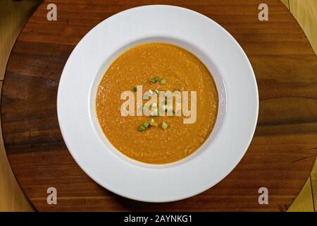Vegetarian, gluten free peanut soup or groundnut soup in bowl. It is made from peanuts, often with carrots, sweet potatoes and scallions. It is a stap Stock Photo