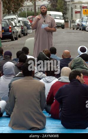 Atilla Ahmet aka abu abdullah leads Friday Prayers in the road outside a Mosque in Finsbury Park, North London following it's closure at the request of the police claiming it had become a meeting point for many radical Muslims. In 2003,150 anti-terrorist police officers conducted a night raid on the building seizing  a stun gun and a CS gas canister, arresting seven men under the Terrorism Act 2000. The Inman Abu Hamza continued to preach each Friday in the street outside the closed mosque until his arrest in May 2004. Stock Photo