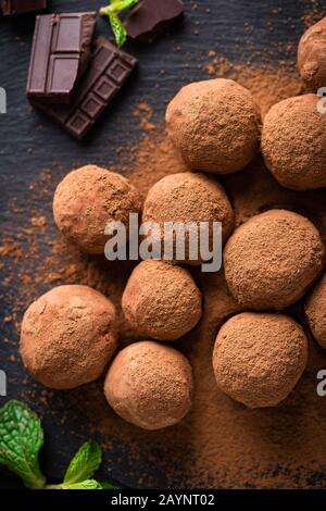 Chocolate truffles in cocoa powder on dark background. Top view Stock Photo