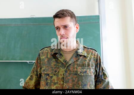 German soldier stands in a classroom . German word Bundeswehr, means german army. Stock Photo