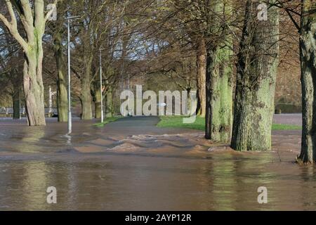 Hereford, Herefordshire, UK - Sunday 16th February 2020 - Flood water from the River Wye pours across a footpath in the adjacent King George V playing fields situated next to the River Wye. The River Wye is expected to peak during the early hours of Monday morning after severe rainfall across Herefordshire and Wales. Photo Steven May / Alamy Live News Stock Photo