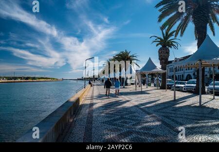 Tourists walking along the promenade at Lagos, Algarve, Portugal Stock Photo