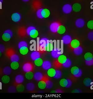 Abstract defocus background, colored green red violet purple dot circle. Illumination blurry lights, pixelated dotted abstract picture of rainbow ligh Stock Photo