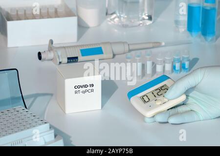 Quick novel COVID-19 coronavirus test kit. 2019 nCoV pcr diagnostics kit. Hand in glove with timer. RT-PCR kit to detect covid19 virus in clinical sam Stock Photo