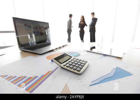 Graphs, charts, laptop calculator on table, workplace of business people Stock Photo