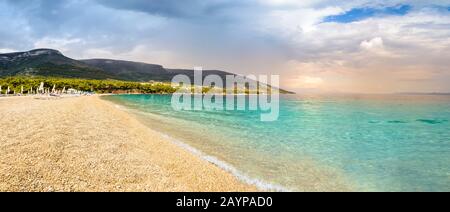 Pebble beach Zlatni Rat or Golden Horn or Golden Cape in Bol town, Brac Island, Croatia. Gravel beach, mountain and turquoise water of Adriatic Sea on Stock Photo