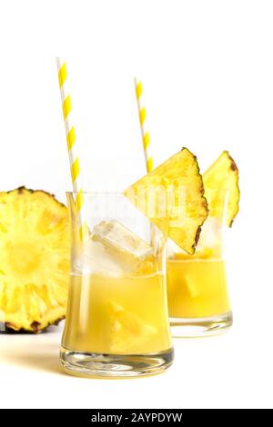 Glass of pineapple juice with a straw and slices of pineapple isolated on white background Stock Photo