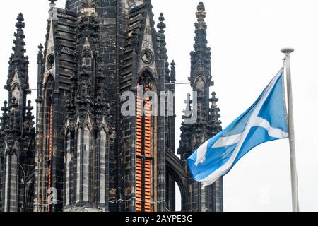Edinburgh, Scotland, Flag of Scotland waving in front of the tower of The Hub or Victoria Hall, former Highland Tolbooth St John's Church Stock Photo