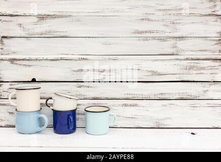 Enameled mugs in retro style on an old wooden background. Selective focus. Stock Photo