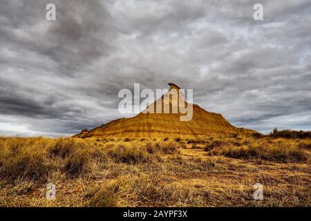 Extreme Desert landscape with dramatic sky background and famous Peak Castil de Tierra in Bardenas Reales, Navarra, Spain, Europe Stock Photo