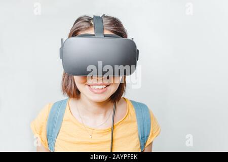 Young woman using a virtual reality headset at white background Stock Photo