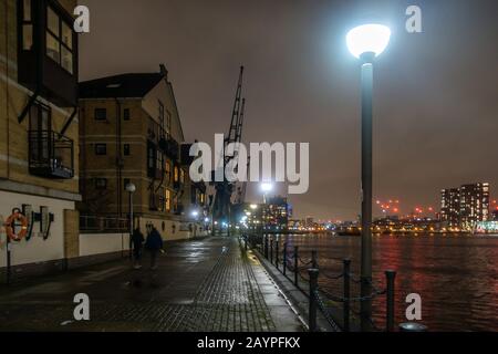 A view along the dockside at night at The Royal Victoria Docks in London, England Stock Photo