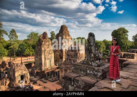 Beautiful Thai girl on the top of the Pre Rup Temple site among the ancient ruins of Angkor Wat Hindu temple complex in Siem Reap, Cambodia. Built as Stock Photo