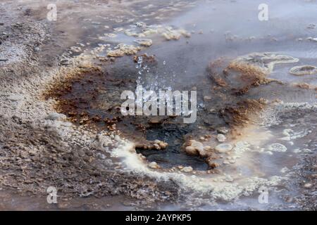 Hot springs spouting water at Hveravellir, a geothermal area of fumaroles and multicolored hot pools in the central highlands of Iceland. Stock Photo