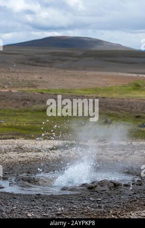 Hot springs spouting water at Hveravellir, a geothermal area of fumaroles and multicolored hot pools in the central highlands of Iceland. Stock Photo