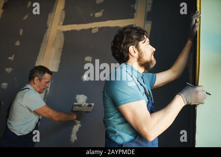 Low angle view of construction crew working in room while building or renovating house, copy space Stock Photo