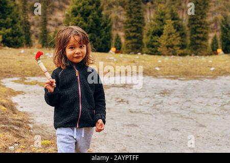 Bishkek, Kyrgyzstan - April 9, 2019: International mointain day. A little girl smiles at the camera. Homeless little child Stock Photo