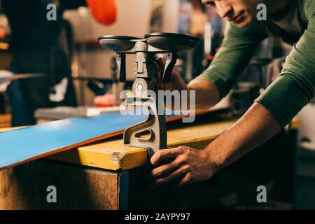 cropped view of worker holding grip vice in repair shop Stock Photo