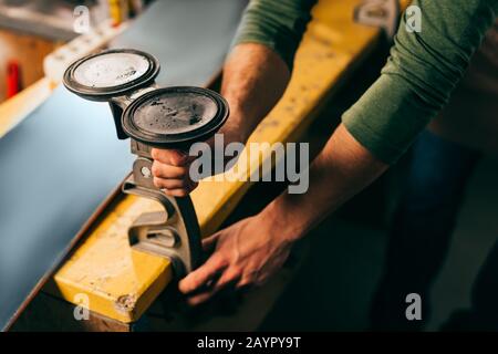 cropped view of worker holding grip vice in repair shop Stock Photo