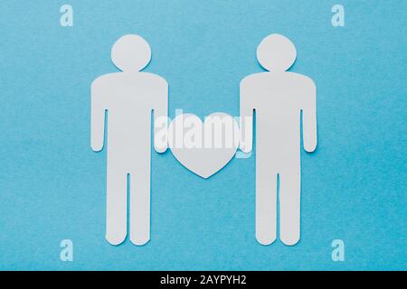 top view of paper cut figures of homosexual couple isolated on blue, human rights concept Stock Photo