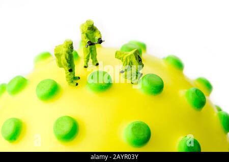 closeup of big corona virus with a team of special medical forces miniature figurines interfering during gas and other chemical accidents, the team pr Stock Photo