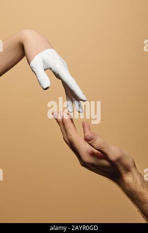 cropped view of man and woman with painted hand touching each other isolated on beige Stock Photo