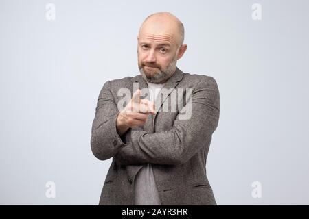 Angry attractive mature man pointing a finger towards you. I blame you in all my problems. Studio shot Stock Photo