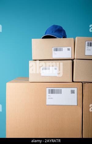 Stacked cardboard boxes with qr and barcodes on cards isolated on blue ...
