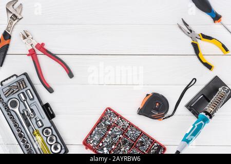Top view of tools with soldering iron and pliers on white wooden background Stock Photo