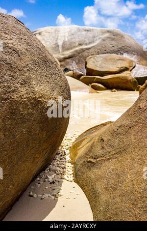 Boulders, shells, bits of coral and waves near Nudey Beach on Fitzroy Island in the Coral Sea off the coast of tropical Queensland Australia. Stock Photo