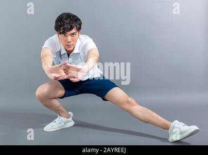 young man runner doing stretching exercise Stock Photo