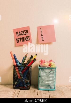 Writing note showing Hacker Spyware. Business concept for infiltration software that secretly monitor unsuspecting user Two Pink Sticky Notes on Wall Stock Photo