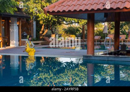 A model shoot at the Rupar Mandalar Resort in Mandalay, Myanmar with a model at the swimming pool of the hotel. Stock Photo