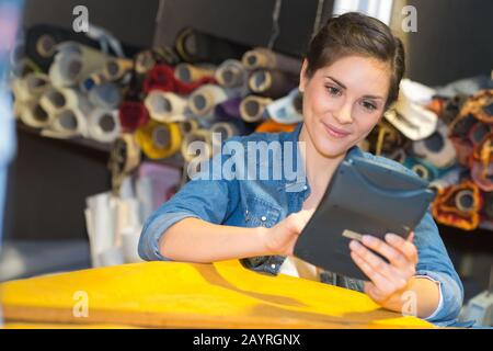female upholsterer doing some measurement calculations Stock Photo