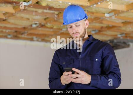 builder with van checking text messages on mobile phone Stock Photo