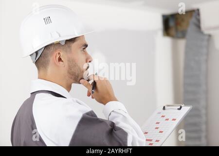 smart pensive builder thinking about something indoors Stock Photo