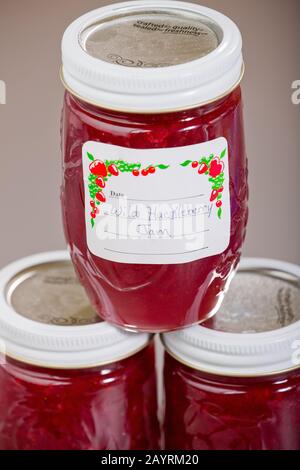Three jars of homemade wild huckleberry jam, with one stacked on top of the other two, made from red huckleberries Stock Photo