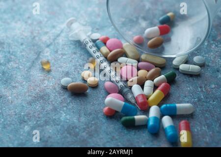 Close up of pill and syringe on table  Stock Photo