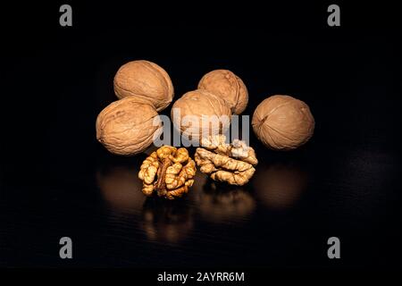 Walnuts on black background. walnut with reflection. nut kernels and whole nuts. Stock Photo