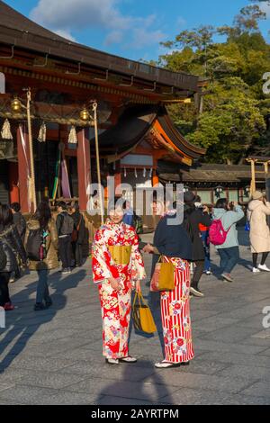 Young women dressed in kimonos posing in front of the Yasaka Shrine, which is a Shinto shrine in the Gion District of Kyoto, Japan. Stock Photo