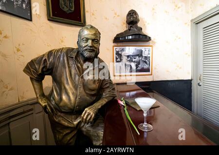 November 26, 2019, Havana, Cuba: Glass of Daiquiri cocktail and statue of American writer Ernest Hemingway in the bar El Floridita in Havanna Stock Photo