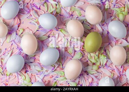 Easter eggs on a spring background, pink with flower petals, soft tones, yellow, white, warm, blue and purple colors. Stock Photo